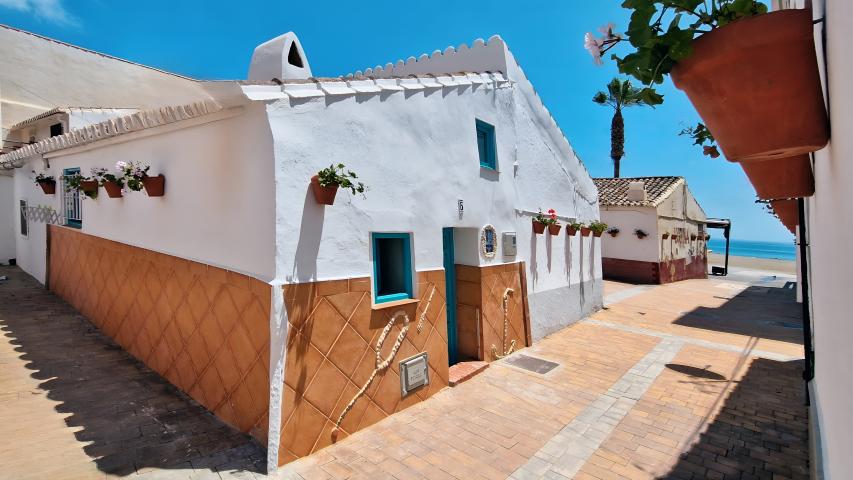 Imagen de Septiembre del Calendario 2026 (Carlos Navarrete) con una instantánea del barrio de pescadores de Rincón de la Victoria